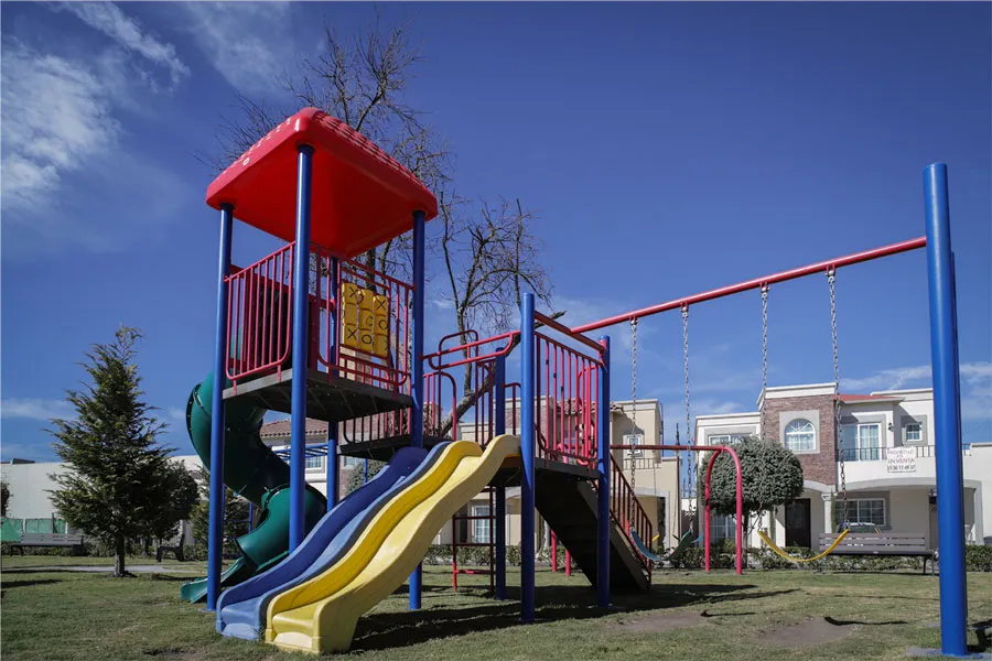 Área de juegos infantiles al aire libre con resbaladilla y columpios