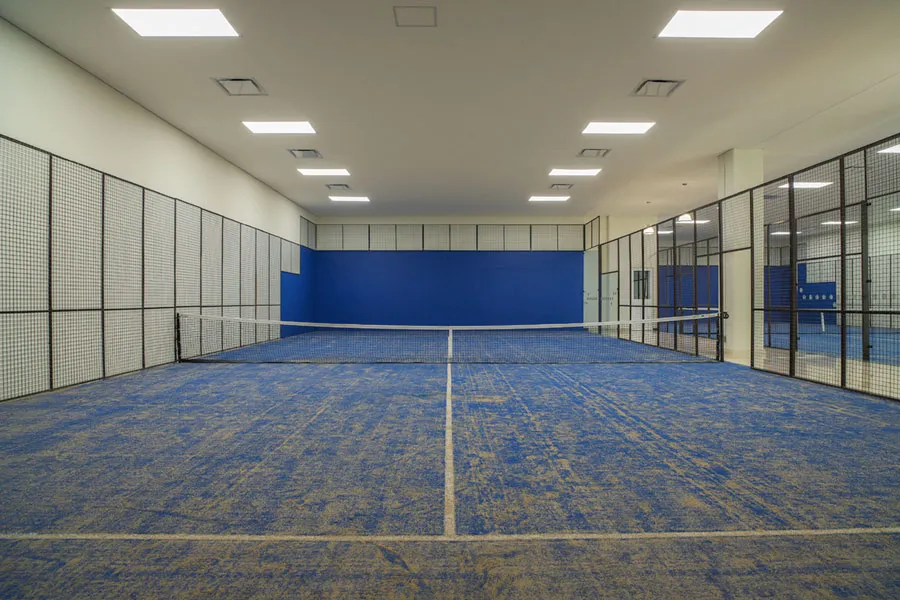 Cancha techada con piso azul y paredes acolchadas