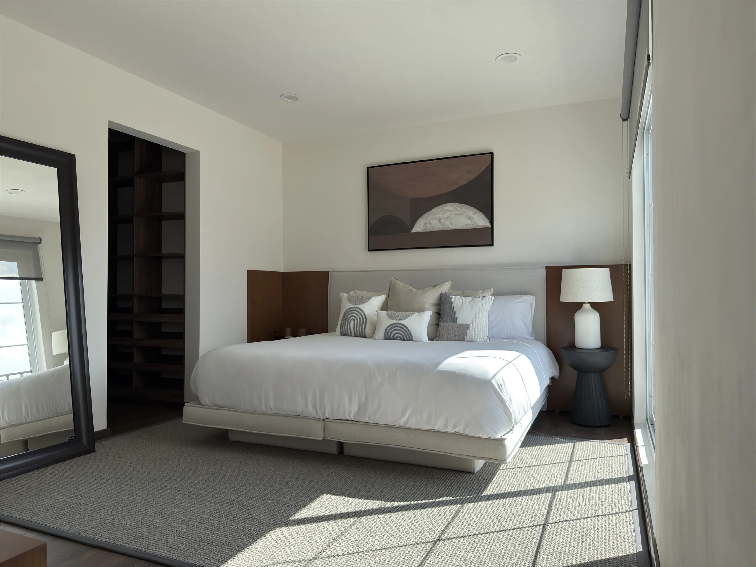 Recámara principal con cama, vestidor y una ventana amplia