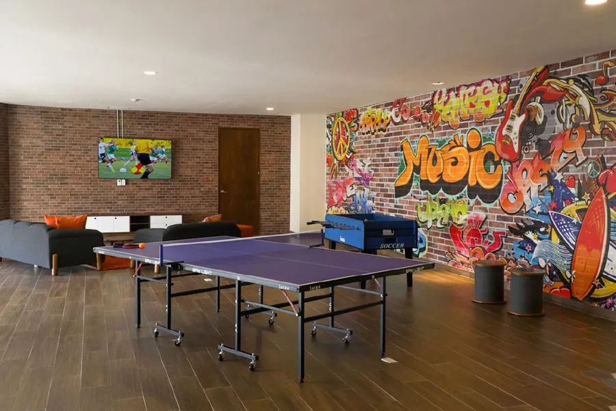 Sala de juegos con mural de grafiti y mesa de ping pong